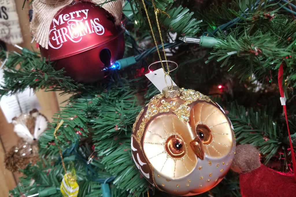 Christmas ornament of owl and holiday bell on a decorated christmas tree